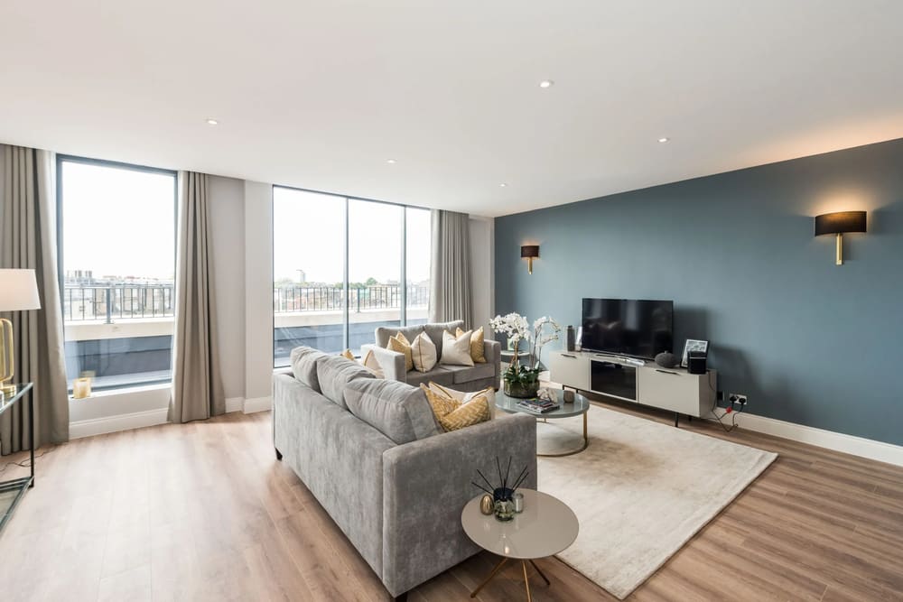 The Carlyle Apartments, Earl's Court: Living room with teal feature wall and large windows