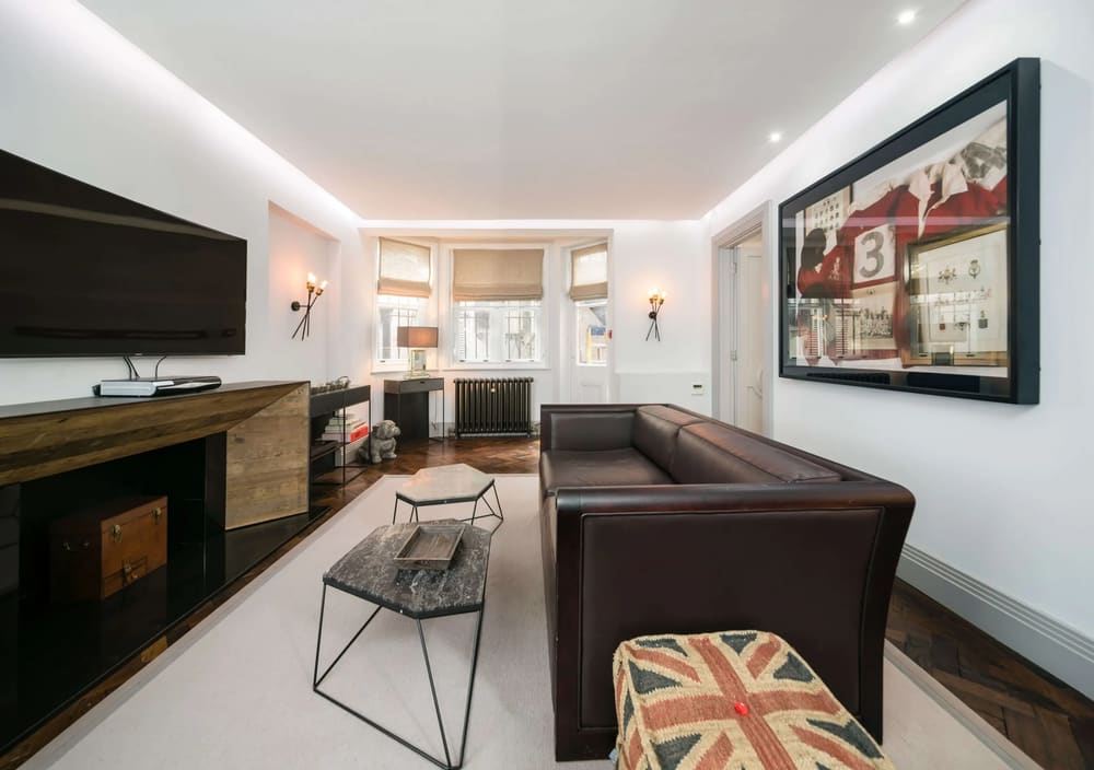 Prime Mayfair 1 bedroom no.4, W1K, Mayfair: Living room with leather sofa and Union Jack footstool