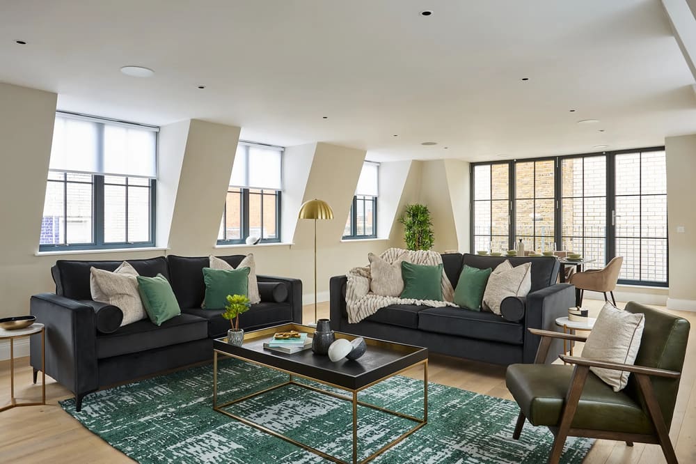 Chancery Lane Apartments, Holborn: Living room with two dark sofas and green rug