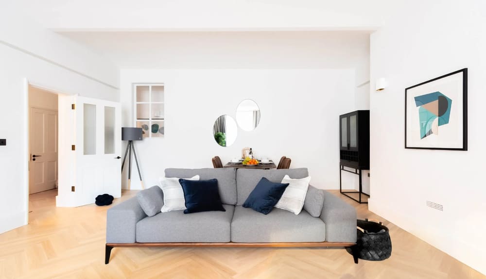 Royal Albert Apartments, Kensington: Grey sofa with navy cushions and herringbone floor