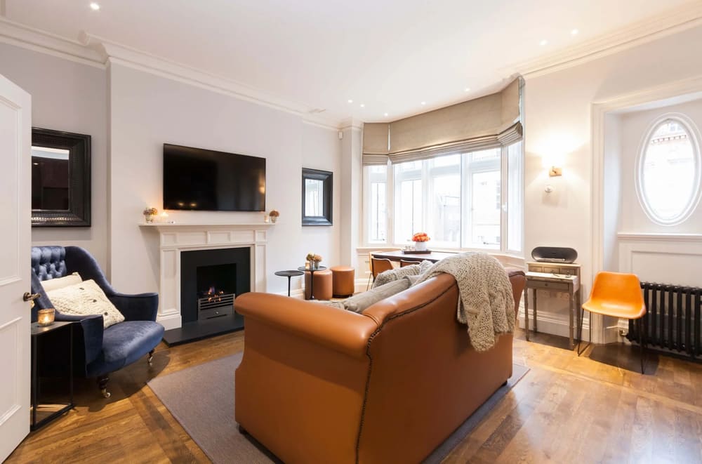 Prime Mayfair 1 bedroom no.1, W1K, Mayfair: Living room with tan leather sofa and fireplace