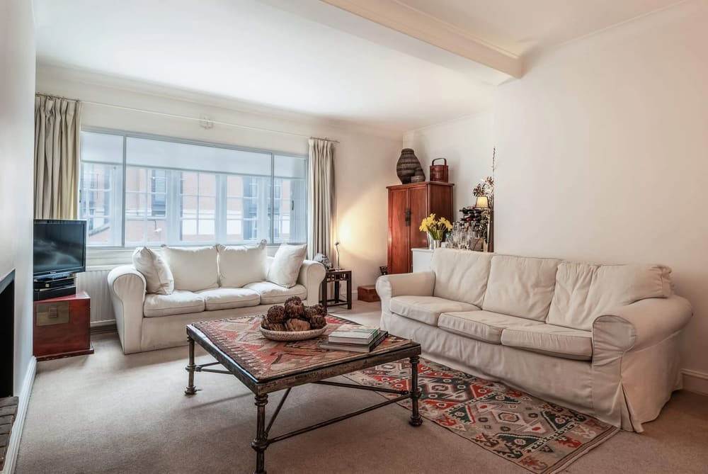 Central Mayfair 2 bedroom, Mayfair: Living room with cream sofas and antique cabinet