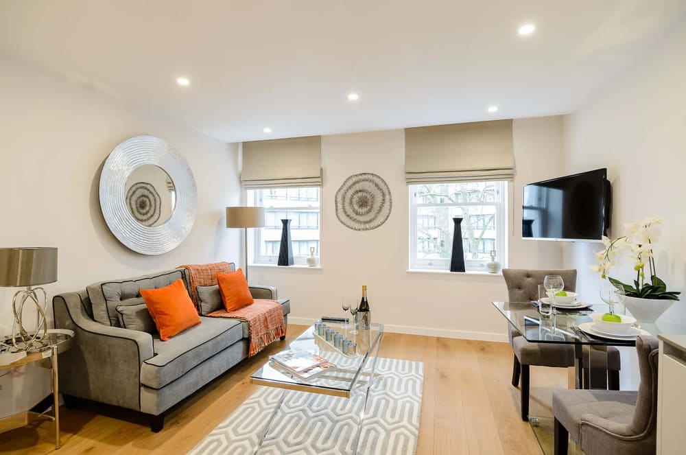 Ashburn Gardens, Kensington: Living room with orange cushions and round mirrors