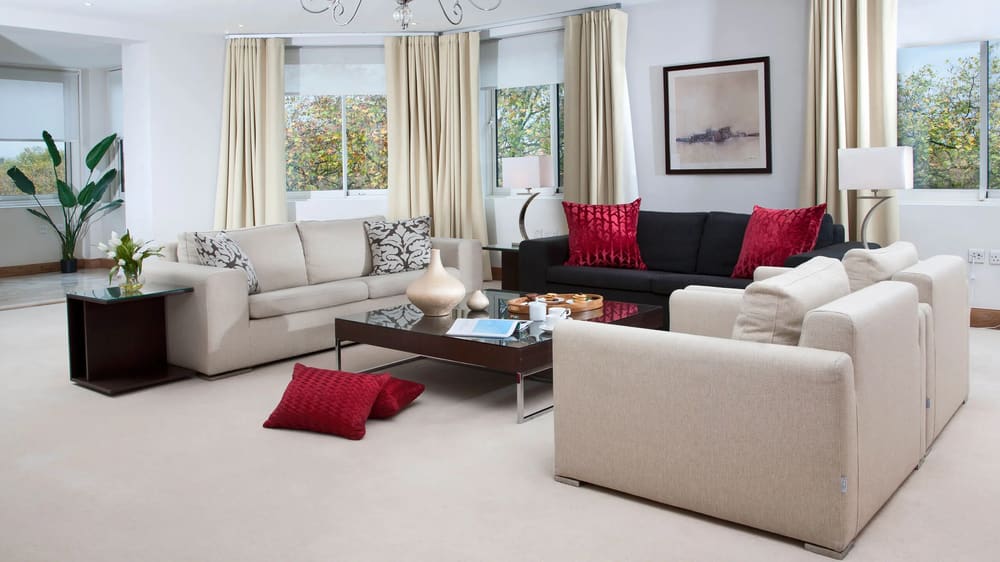 Arlington House, Mayfair: Living room with cream sofas and red cushions