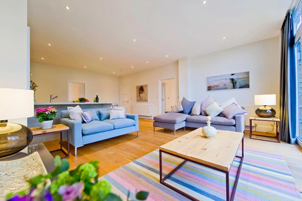 The Claygate Apartments, Claygate: Living room with blue sofas and striped rug