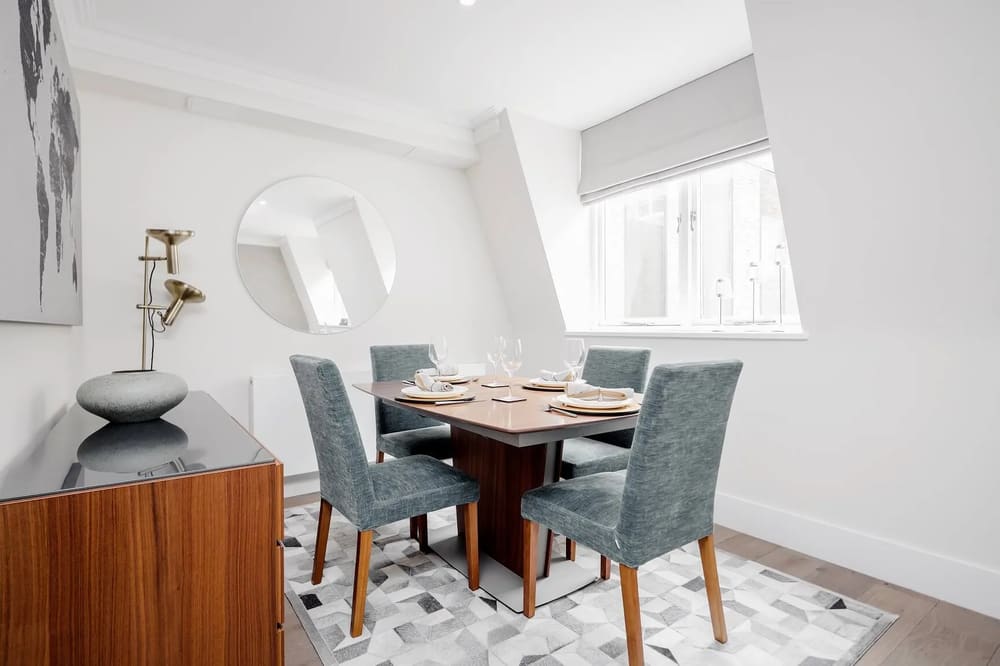 Mayfair Mews Apartment III, Mayfair: Dining table with grey chairs under a sloping ceiling