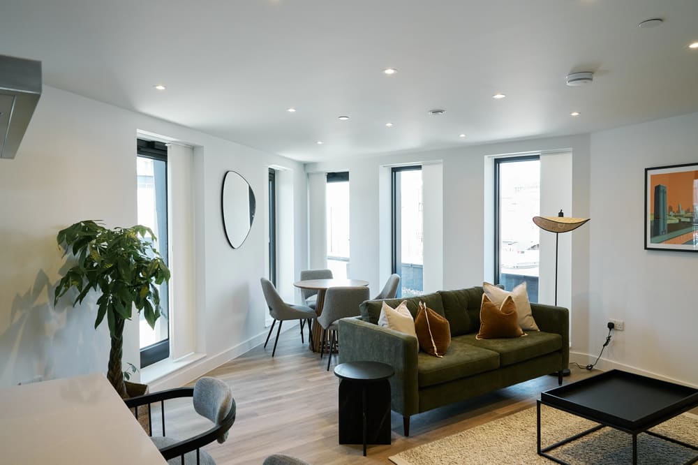 The Kings Cross Apartments, King's Cross: Living room with green sofa and round dining table