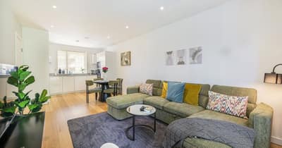 Phoenix Luxury Stays Battersea, Battersea: Seven On Danvers: Grey sofa with patterned cushions beside a dining table, photo 5