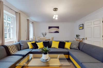 34–36 Clarges Street Apartments, Mayfair: Corner sofa with yellow and grey cushions