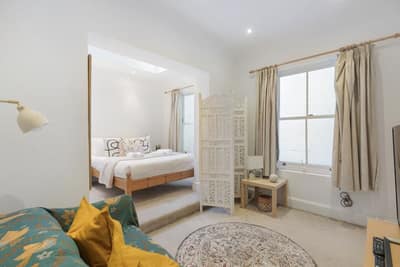 Notting Hill Victorian Duplex, Notting Hill: Bedroom with bed beside large sash window
