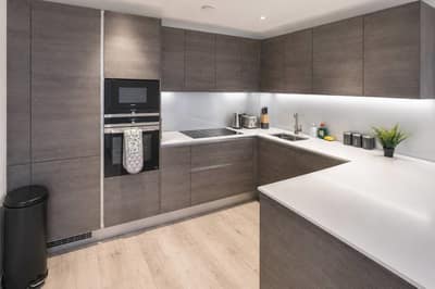 Camley Street Three Bedroom Apartment, King's Cross: Kitchen with dark cabinets and fitted appliances