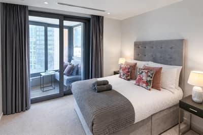 Camley Street Three Bedroom Apartment, King's Cross: Bedroom with double bed beside balcony doors