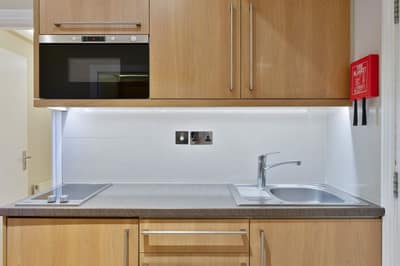 Cleveland Residences Russell Square, Bloomsbury: Compact kitchenette with microwave and wood cabinets
