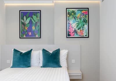 Cromwell Serviced Apartments, Earl's Court: Double bed beneath colourful framed artwork