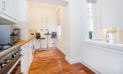 Daventry Street Two Bedroom Apartment, Marylebone: Kitchen with white cabinets and wooden worktop