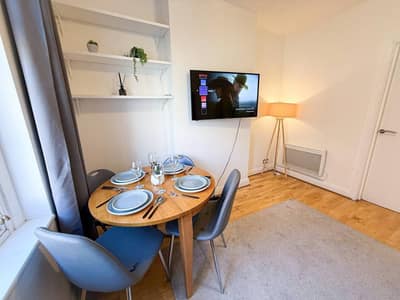 Hackney One Bedroom Apartment, East London: Dining table beside window and wall-mounted television
