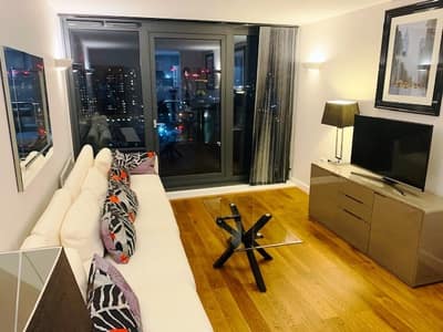 Neutron Tower One Bedroom Apartment, East London: Living room with sofas and framed artwork