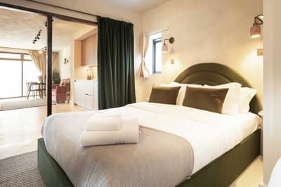 Noxley Fulham Ground Floor Apartment, Fulham: Bedroom with upholstered bed and sloping ceiling