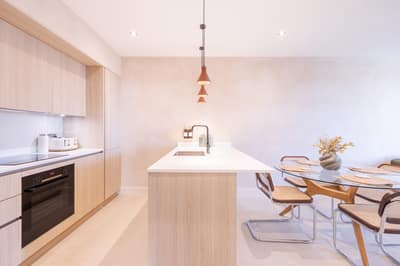 Noxley Fulham Two Bedroom Penthouse, Fulham: White kitchen beside round wooden dining table