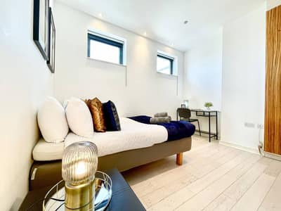 Pentonville Road Three Bedroom Apartment, King's Cross: Bedroom with upholstered bed and arched window