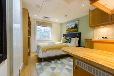 Studios2Let Cartwright Gardens, Bloomsbury: Studio bed beside compact fitted kitchenette
