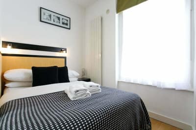 Studios2Let North Gower Street, Central London: Studio bed beside window and wooden wardrobe