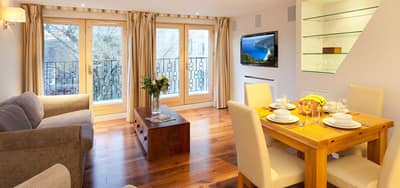 Tavistock Place Apartments, Bloomsbury: Dining table beside sofa and balcony doors