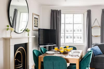 Westbourne Street Three Bedroom Apartment, Paddington: Dining table beside large window and fireplace