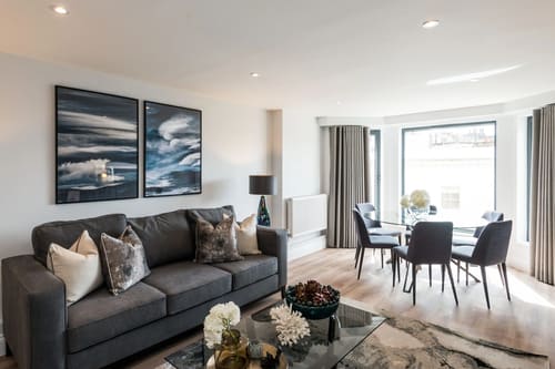 The Carlyle Apartments, Earl's Court: Living room with grey sofa and dining area