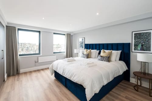 The Carlyle Apartments, Earl's Court: Double bedroom with navy velvet headboard