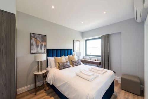 The Carlyle Apartments, Earl's Court: Double bedroom with navy headboard and window seat