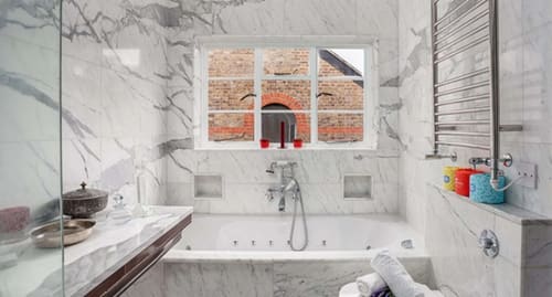 Notting Hill 3 bedroom near Ladbroke Grove, Notting Hill: Marble bathroom with bath under a window