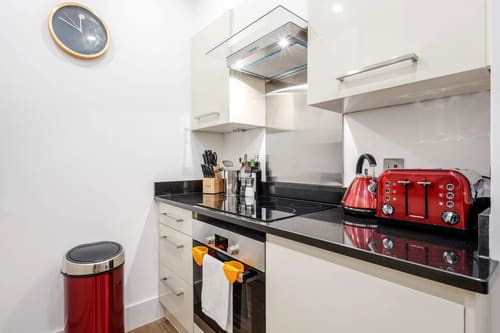 Mayfair Mews Apartment I, Mayfair: Kitchen with black worktops and red kettle