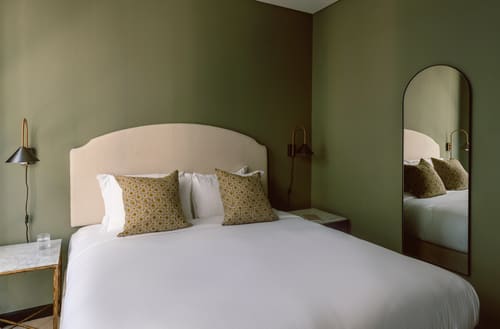 The St Paul’s Apartments, East London: Double bed with cream headboard and green walls