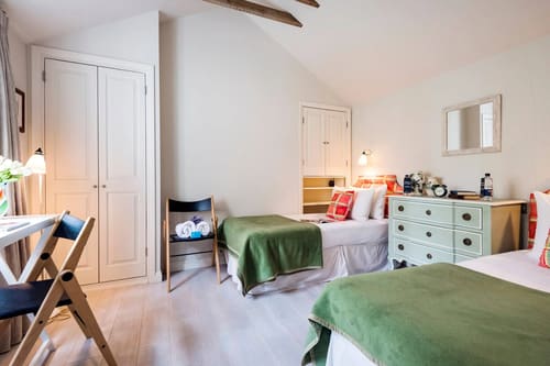 Secluded 2 bedroom Belgravia House, Chelsea: Twin beds with green throws under sloping ceiling