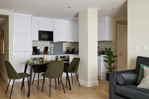 Chancery Lane Apartments, Holborn: Open-plan kitchen with dining table and green chairs