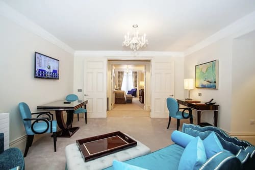 The Sloane Club Apartments, Chelsea: Sitting room with desk, blue chairs and chandelier