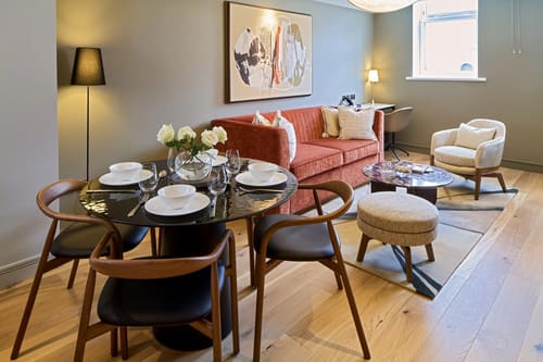 Cheval Phoenix House, Chelsea: Dining table with terracotta sofa beyond