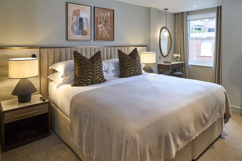 Cheval Phoenix House, Chelsea: Double bedroom with upholstered headboard and artwork