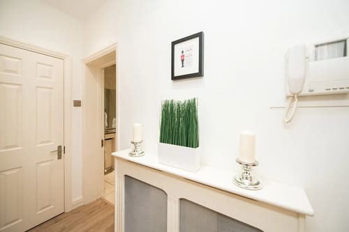 Nassau Street Chic, Fitzrovia: Hallway with radiator cover and framed print