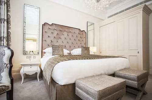 The Sloane Club Apartments, Chelsea: Bed with tall buttoned headboard and chandelier
