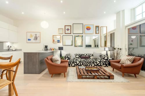 Colonnade, Bloomsbury: Living room with gallery wall and leather armchairs