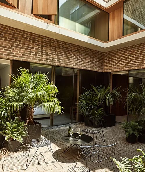 Marylebone Mews Apartments, Marylebone: Courtyard with brick wall and potted palms