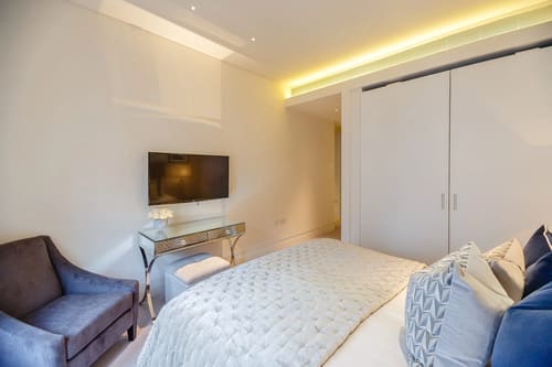 Green Street, W1K, Mayfair: Bedroom with wall-mounted TV and fitted wardrobe