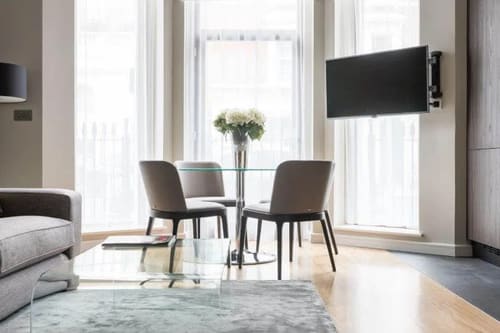 One Harrington Gardens, Kensington: Dining table with grey chairs by tall windows