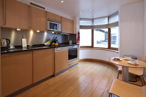 Cheval Knightsbridge, Knightsbridge: Kitchen with wood units and curved bay window