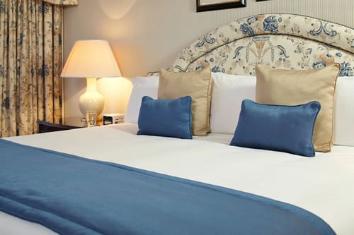 Cheval Thorney Court, Kensington: Bed with floral headboard and blue cushions