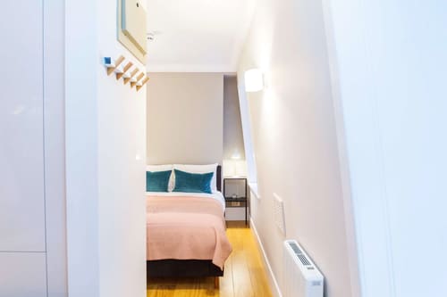 The Bank Apartments, East London: Narrow bedroom with pink bedding