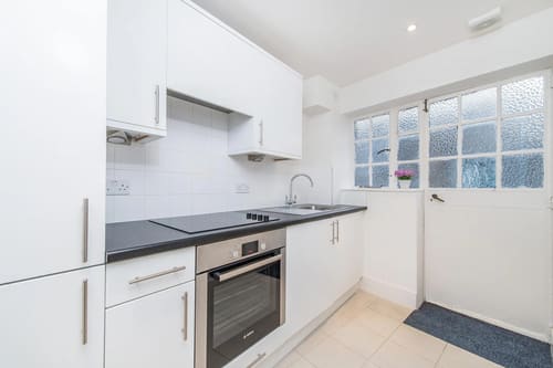 Chelsea Mansion Block, Chelsea: White kitchen with hob, oven and garden door