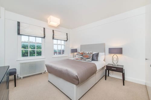 Chelsea Mansion Block, Chelsea: Double bedroom with grey headboard and radiator